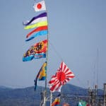 Fishing boats sport colorful flags during a fleet celebration.