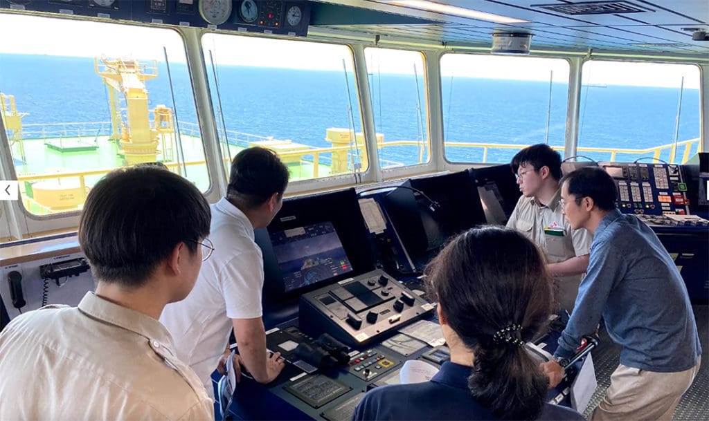 Captain and crewmembers observe the operation of the HiNAS AI nav system aboard Prism Courage.