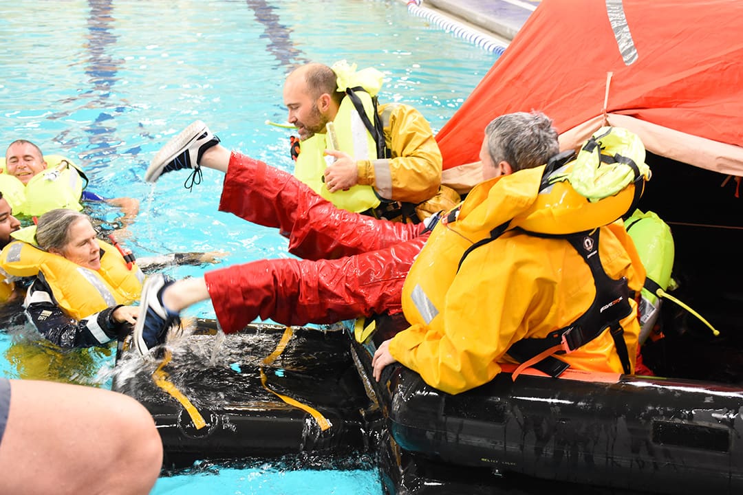 Participants learn what it takes to get into a life raft from water level.