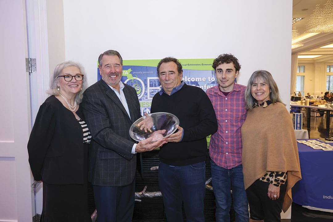 Warren Kelly (center) accepts the MMTA Frank Farrell Distinguished Service Award from Larry Russo, alongside (L to R) MMTA President Marie Hayward, Dylan Kelly and Lisa Kelly.