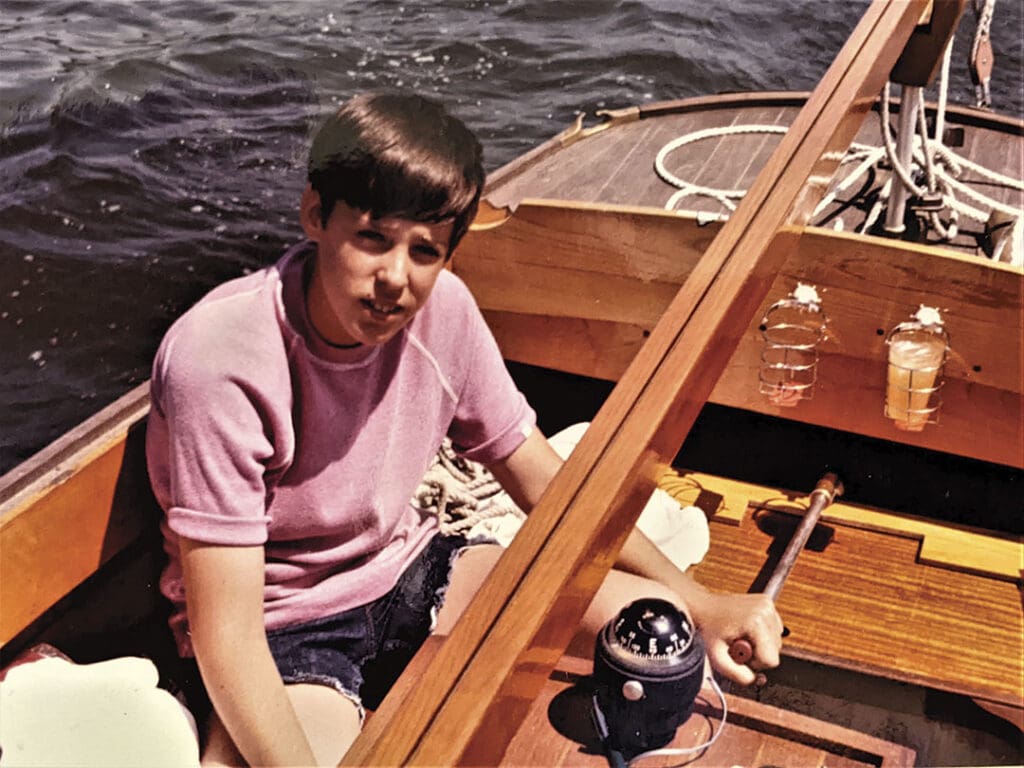 At the helm of his vessel. A young Robert Beringer, below, takes the helm of his father’s wooden sailboat.